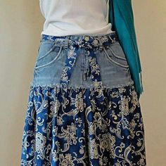 a woman wearing a blue skirt with white flowers on it