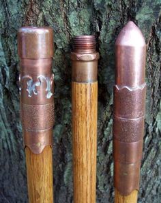 two wooden and metal pens sitting next to a tree