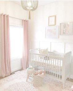 a white crib with pink drapes and curtains in a baby's room