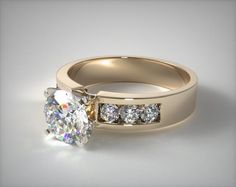 a white gold engagement ring with three stones on the side and a channeled band