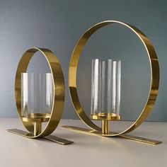 two gold candle holders sitting on top of a table