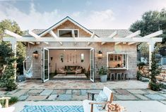 an outdoor living area with patio furniture and stone pavers flooring, surrounded by greenery