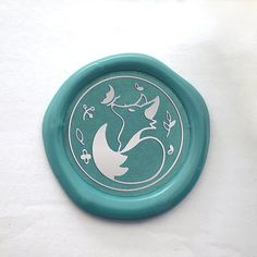 a green frisbee with white designs on it sitting on a table next to a wall