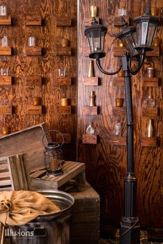 an old fashioned street light next to a wooden wall