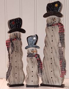 three snowmen with hats and scarfs standing next to each other