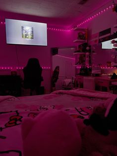 a person sitting in a room with pink lights on the walls and a hello kitty bed