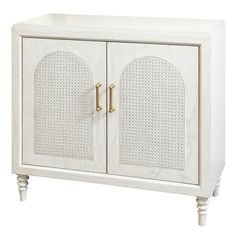 a white cabinet with two doors and gold handles