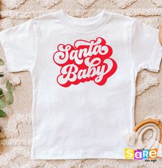 "Santa Baby, Christmas Kids Shirt, Holiday Toddler Tee, Merry Vibes Onesie®, Cute Christmas Bodysuit, Holiday Baby Onesie®, Santa Toddler Tee, Winter Season Tee, Cute Baby Onesie®, Holiday Season Shirt, First Christmas Outfit, Xmas Baby Clothes, Xmas Youth Shirt, Cute Youth Tee, Retro Christmas Shirt Welcome to SareKidsStyle! HOW TO ORDER * Please review all the information provided before placing an order. 1. Select the style and size using the drop-down menu. 2. Select color 3. [APPLICABLE ONLY ON CERTAIN LISTINGS] Follow the instructions to fill out the \"Add your personalization\" option, e.g., specifying custom sayings or selecting design colors. 4. Select quantity Need more Items? Add the current item to the cart. And if you like to add more items to your order, please press the back White Tops For Christmas Birthday, Festive White T-shirt With Letter Print, First Christmas Outfit, Christmas Bodysuit, Christmas Shirts For Kids, Christmas Tops, Youth Shirt, Christmas Kids, Screen Printing Shirts