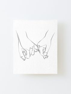 two hands holding each other over a white square canvas mounted on the side of a wall