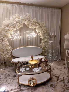 a table with white flowers and candles in front of a sign that says better together