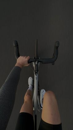 two people are riding bikes with their feet on the handlebars