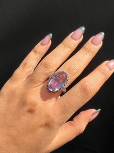 Vintage silver Victorian gothic ring from Ireland featuring an enchanting oval cut amethyst nestled in a rhinestone halo setting. Great vintage condition, one rhinestone missing Size: 5.75 resizable* Weight: 6.3 grams Band: 28.3 mm (front), 1.4 mm (back) Amethyst: 20.0 mm x 11.5 mm oval cut Hallmarks: 'Stfuling' for maker's mark Gothic Ring, Gothic Rings, Halo Setting, Victorian Gothic, Maker's Mark, Makers Mark, Oval Cut, Vintage Silver, Halo