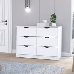 a white dresser with black drawers in a room