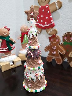 a group of gingerbread christmas trees sitting on top of a table next to cookies