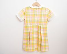 Step back in time with the perfect vintage-inspired dress for your little girl this spring and summer. Featuring the sweetest plaid print in bright cheery colors, and the sweetest reverse peter pan collar for a super cool 60s mod detail, your little one will be irresistibly cute. Not only will they look absolutely cute in this timeless piece, they will be so comfortable since it's made from a stretchy cotton spandex blend material. What's better than sweet vintage style with modern comfort for a Spring School Dress With Peter Pan Collar, Spring School Dress With Collar, Collared Spring Dresses For School, Preppy Gingham Dress For School, Yellow School Dress For Spring, Yellow Spring Dresses For School, Plaid Summer Dress For School, Plaid Dresses For School In Summer, Plaid Dresses For Summer School