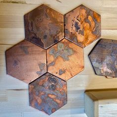 four metal hexagons are hanging on the wall