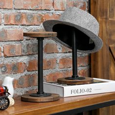 a hat sitting on top of a wooden table next to a book and figurine