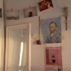 there are pictures on the wall above the mirror and door to another room in the house