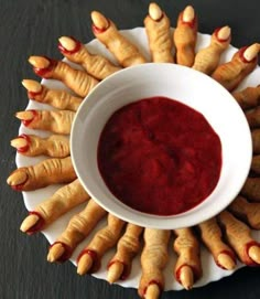 a white bowl filled with red liquid surrounded by yellow and orange spiky fingers