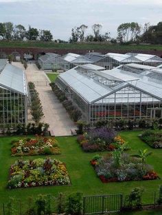 an aerial view of several greenhouses with flowers in the foreground