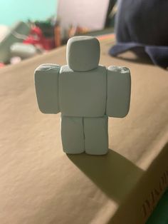 a small white figurine sitting on top of a book