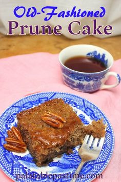 a blue and white plate topped with cake next to a cup of tea