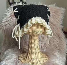 a black and white hat sitting on top of a wicker table next to a mirror