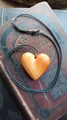 a book with a wooden heart on it and a string attached to the front cover