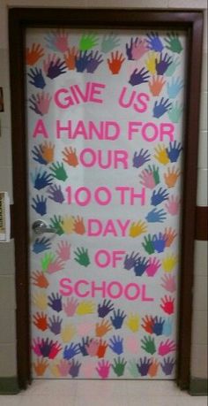 a classroom door decorated with handprints and the words give us a hand for our 100th day of school