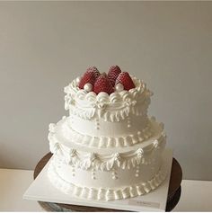 a three tiered cake with strawberries on top