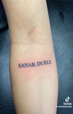 a small tattoo with the word sanar duple on it's left arm