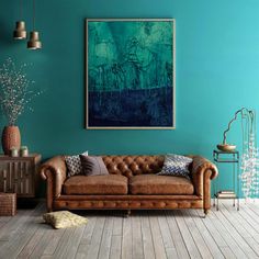 a living room with blue walls and leather couches in front of a painting on the wall