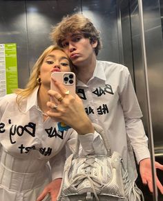 a man and woman taking a selfie in an elevator