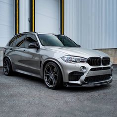 a silver bmw suv parked in front of a building