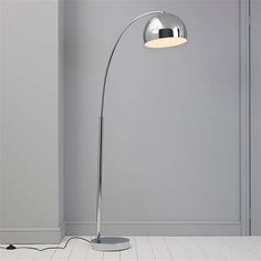 a modern floor lamp in an empty room with grey walls and white tile flooring