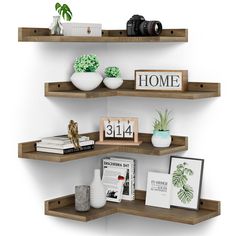 three wooden shelves with books, plants and pictures on them