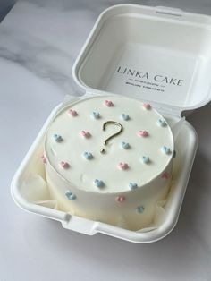 a cake in a box with a question mark on it