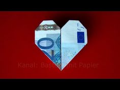 an origami heart shaped bank note on a red background