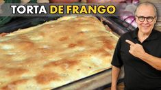 a man standing next to a tray of food with the words torta de frango on it