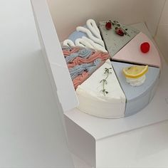 a cake that is sitting on top of a white box with slices of lemon and strawberries