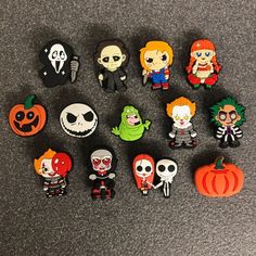 a collection of halloween pins and magnets sitting on a table next to each other