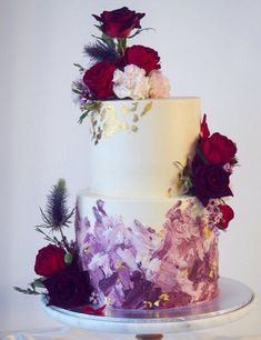 a three tiered cake with flowers on top