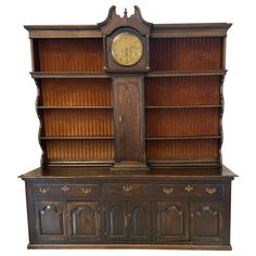 an old wooden bookcase with a clock on it's front and side shelves