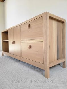 a wooden cabinet sitting on top of a carpeted floor next to a white wall