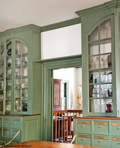 a kitchen with green cabinets and glass doors