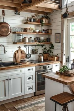 a kitchen with white cabinets and wooden shelves