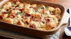 a casserole dish with bacon, cheese and spinach in it on a table