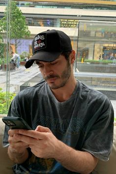 a man sitting on a couch looking at his cell phone