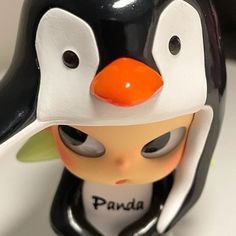 a close up of a penguin figurine on a white surface with black and orange accents