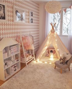 a child's bedroom decorated in pink, white and grey with a teepee tent